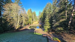 A forested area with a pond, a wooden deck, and a gazebo. - Forest Cabin - Hot Tub - Fast WiFi - Fire Pit On Site (Duncan)