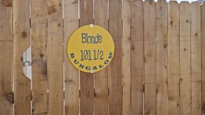 Ein Holzzaun mit einem gelben Schild, auf dem 'Blonde 1011/2 BUNGALON' steht.