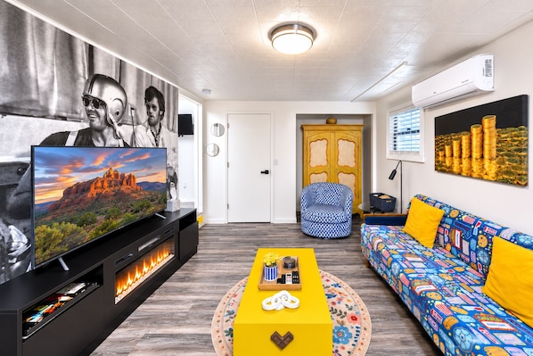 A modern living room with a flat-screen TV, a fireplace, a sofa, and a coffee table.