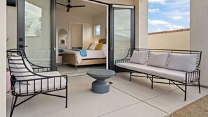 Un balcon avec un lit, un canapé et une chaise.