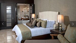 Una habitación de hotel con una cama grande, dos mesitas de noche con lámparas, una silla y un espejo.