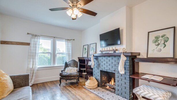 A living room with a fireplace, a sofa, a chair, a television, and a bookshelf.