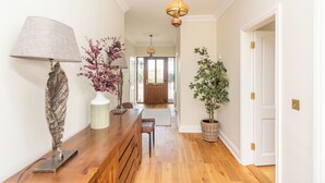 A hallway with wooden flooring, a bench, a lamp, and potted plants. - 5 Bed Villa  - Sleeps 10 - Hot Tub - Country Views (Waterford)