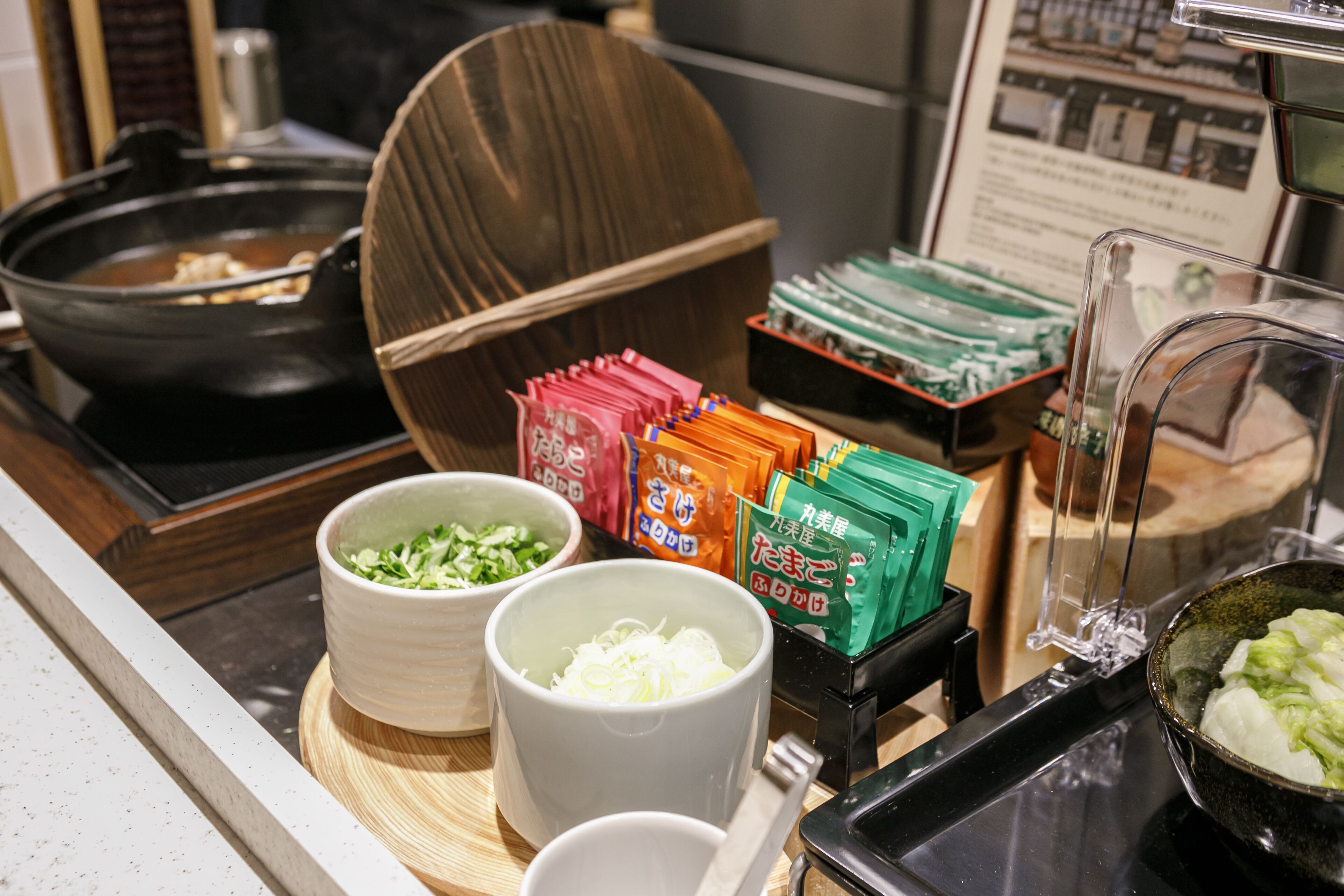 A buffet setup with various food items and condiments.