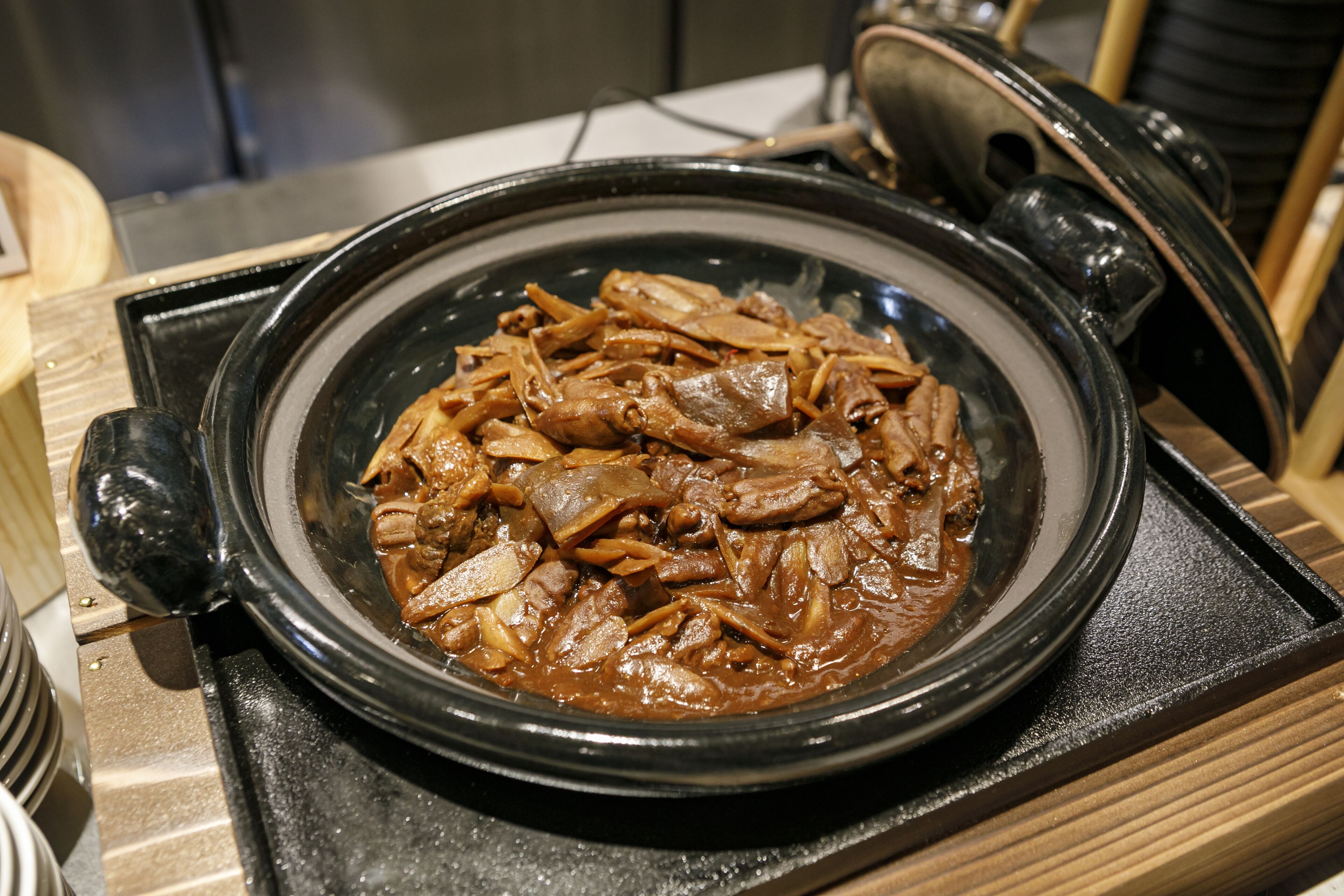 A black ceramic pot filled with a brown dish on a stove.