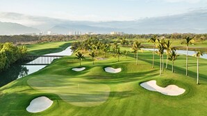 A golf course with sand bunkers, palm trees, and a water hazard. - PGA Tour - Luxury Suite steps from the course! (Nuevo Vallarta)
