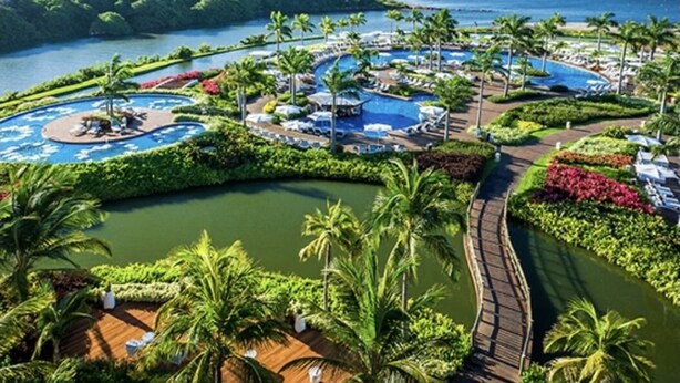 A resort with multiple swimming pools, palm trees, and a view of the ocean. - PGA Tour - Luxury Suite steps from the course! (Nuevo Vallarta)