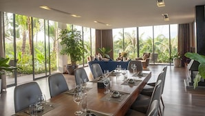 A modern conference room with a long table, chairs, and potted plants. - Flamingo Dai Lai Resort Vila Tu Nhan BBQ (Vinh Phuc)
