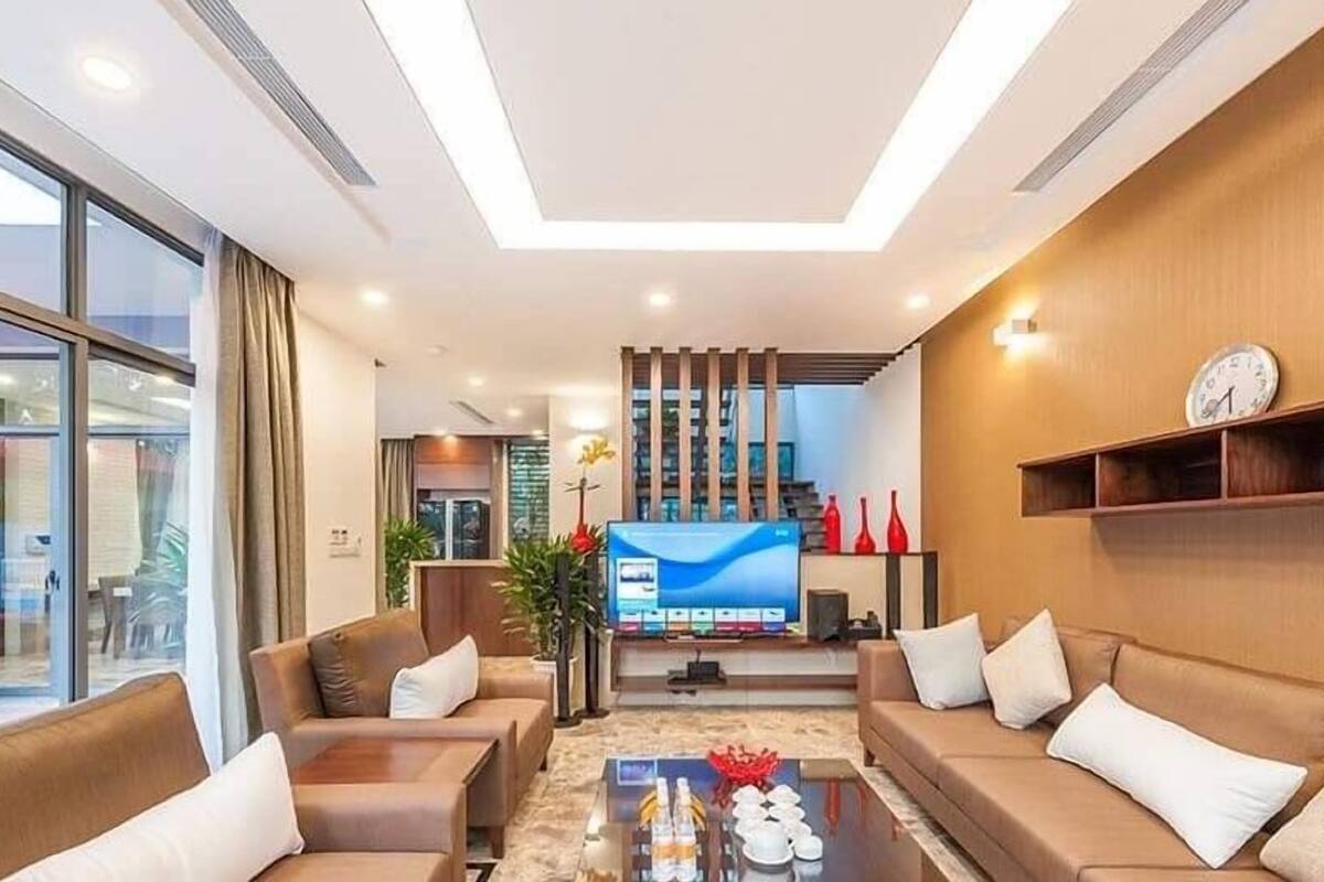 Un salon moderne doté d’un téléviseur à écran plat, de canapés, d’une table basse et d’une grande fenêtre.