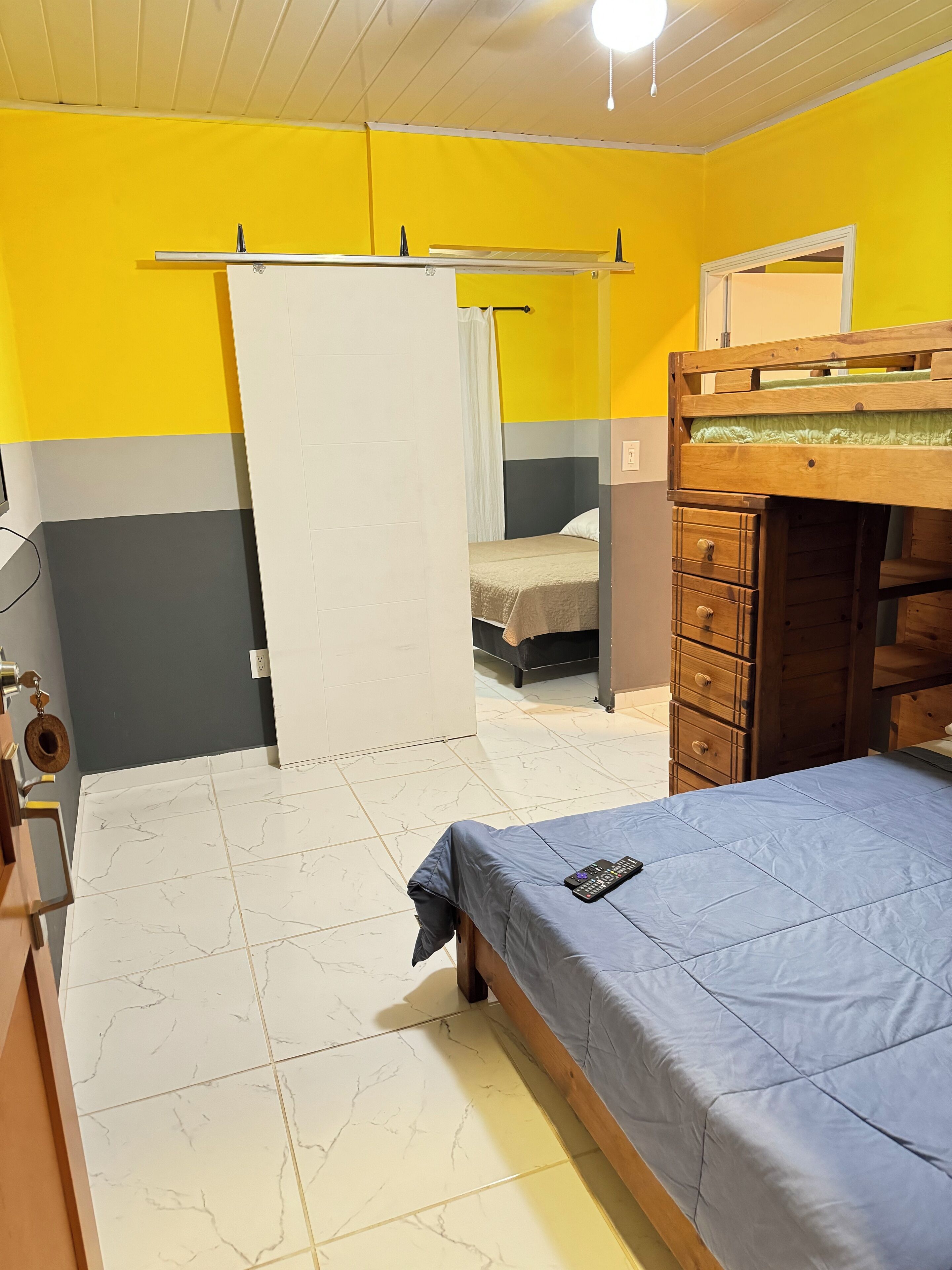A bedroom with a bed, a dresser, a mirror, and a wardrobe.
