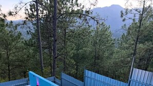 A swimming pool with a tiled edge, surrounded by a metal fence, and trees in the background. - Hotel Aoki valle de ángeles  (Valle de Angeles)