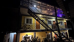A multi-story building with a staircase leading to the upper floor, a balcony, and a sign indicating it is a hotel. - Hotel Aoki valle de ángeles  (Valle de Angeles)