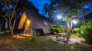 A small, rustic cabin with a sloped roof, surrounded by lush greenery and trees. - Cashewnut Tree Resort (Ko Lanta)