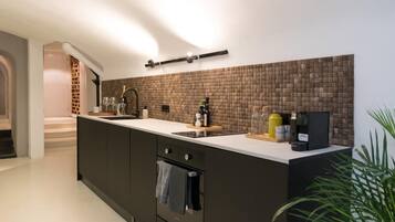 Een koffiezetapparaat/waterkoker, een koelkast, een oven, een vaatwasser