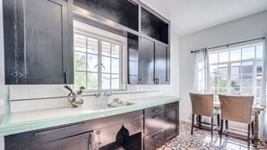 A kitchen with dark cabinets, a green countertop, a sink, and two chairs near a window. - 1926 Original Firehouse / Close to U of A / Loft (Tucson)