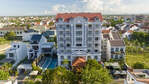 Un grand hôtel doté de nombreux balcons, d’une piscine et offrant une vue sur le quartier environnant.