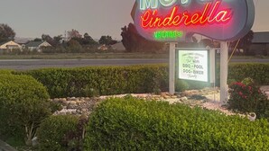 Un letrero de motel de neón que dice 'Cinderella' con un cartel de 'HABITACIONES DISPONIBLES' debajo.