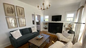A living room with a sofa, a coffee table, and a fireplace.