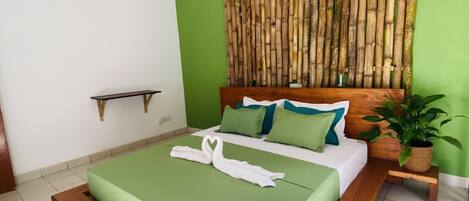 A modern bedroom with a wooden bed frame, green bedding, and a bamboo wall decoration.