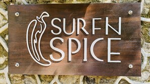 A wooden sign with the text "SURF N SPICE" and a stylized surfboard design. - SURF N SPICE (Dikwella)