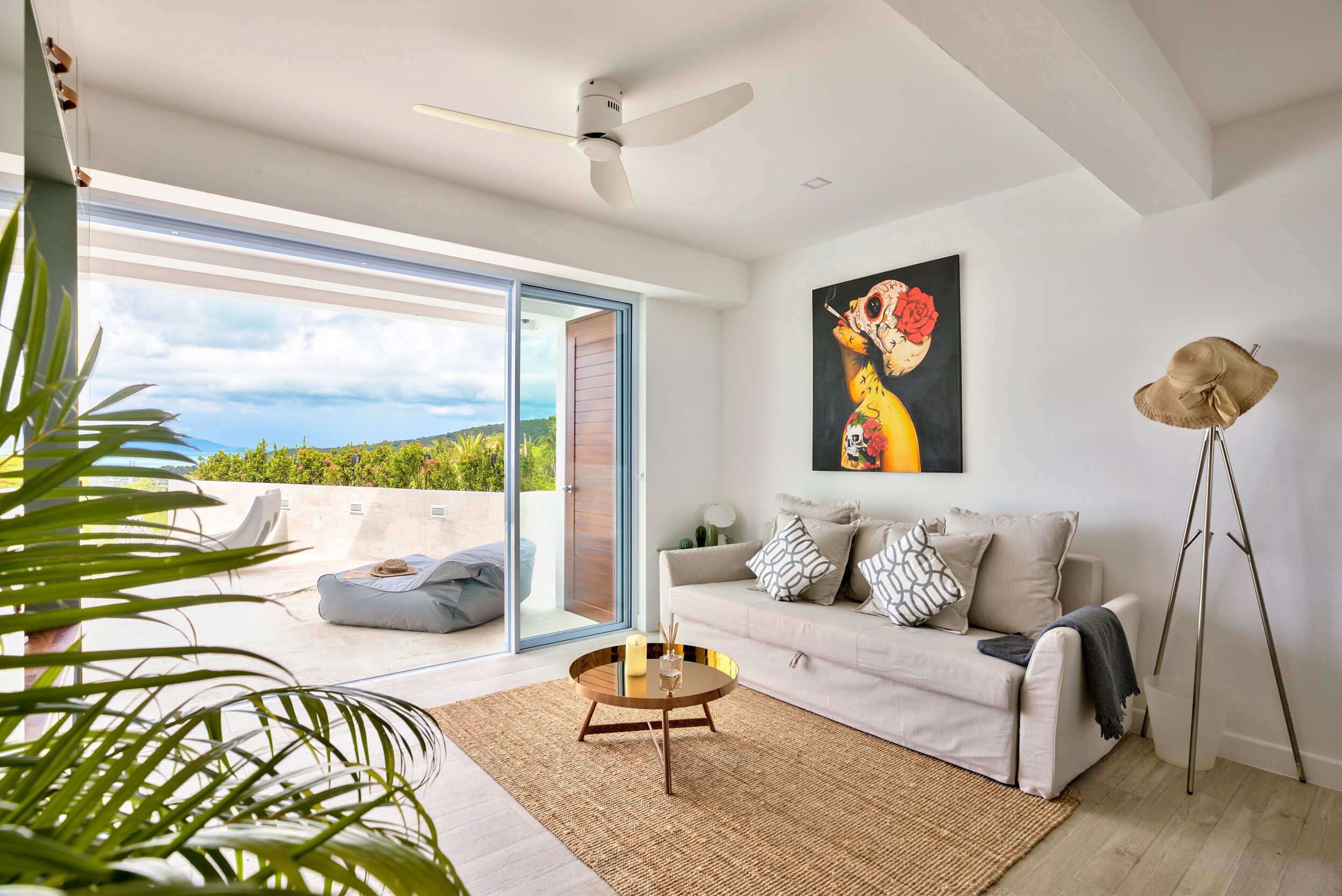 A modern living room with a sofa, a coffee table, and a painting on the wall.