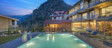 Ein Hotel mit Schwimmbad, Außenbereich und Blick auf die Berge.