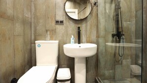 Een badkamer met toilet, wastafel en douche.