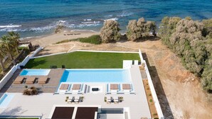 Vista aérea de un resort con piscina, zonas de descanso y playa.