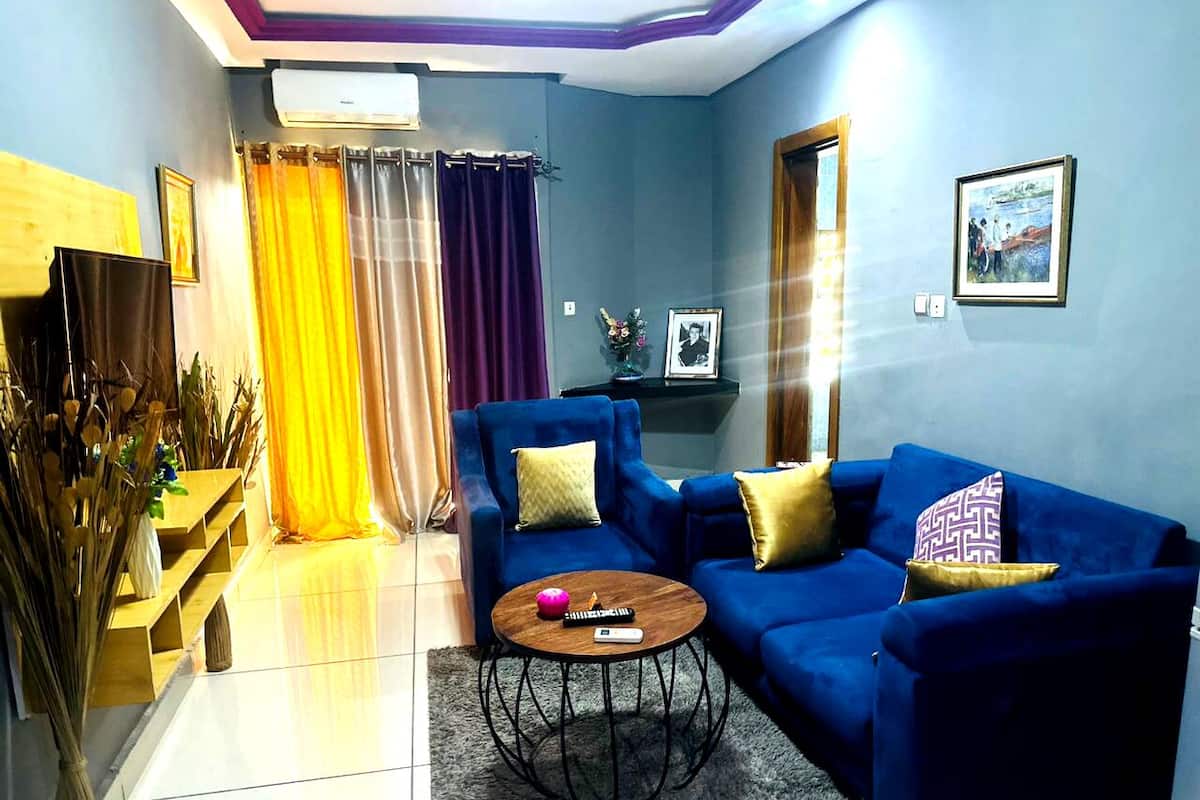 A living room with a blue sofa, a coffee table, and a TV.