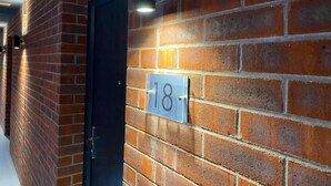 A brick wall with a number sign indicating room 18. - Immaculate 1-bed Apartment in Sheffield (Sheffield)