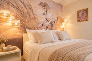 Un dormitorio con un gran mural de un caballo, una cama con muchas almohadas y lámparas fijadas a la pared.