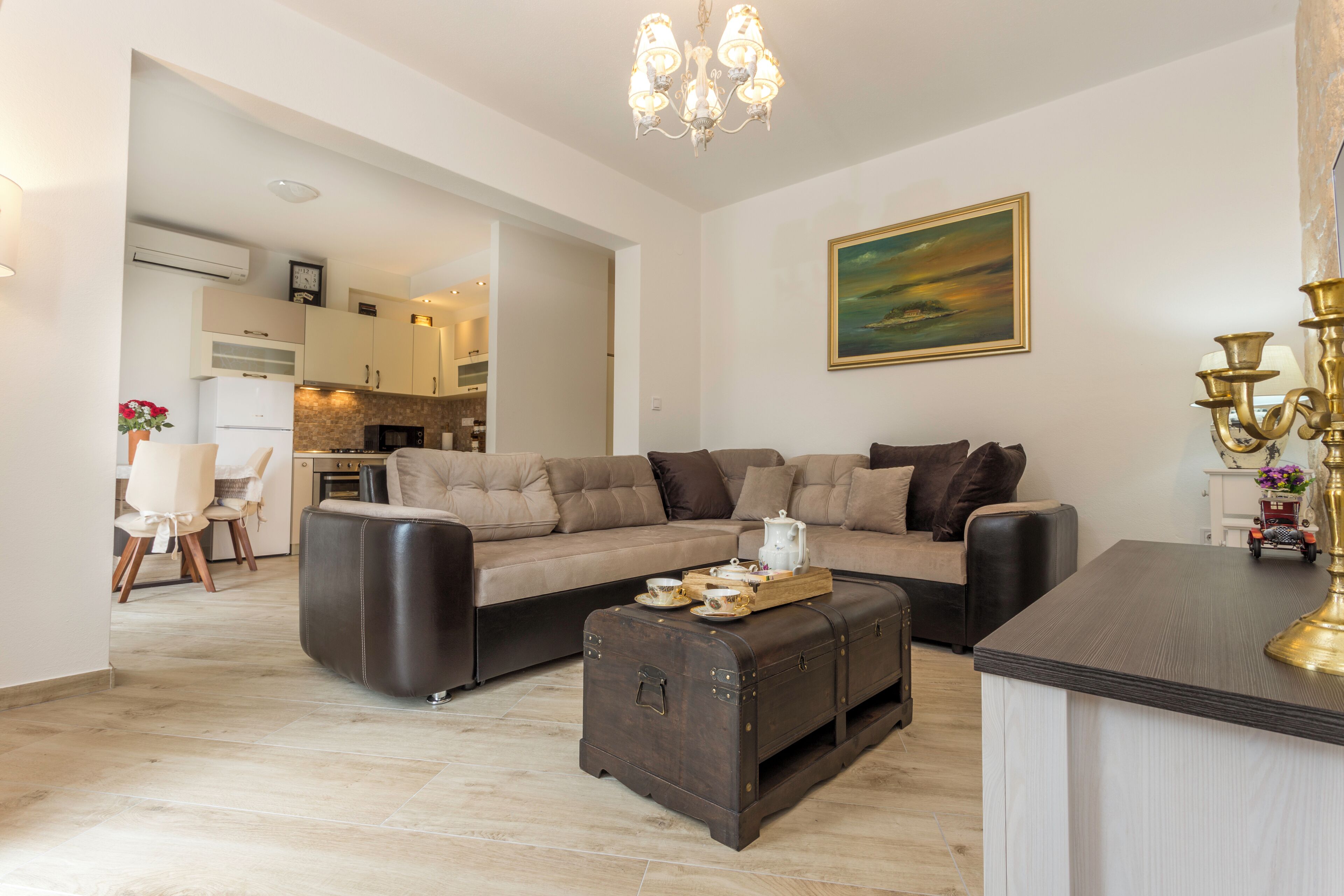 Un salon moderne avec un canapé, une table basse et un coin repas visible au fond.