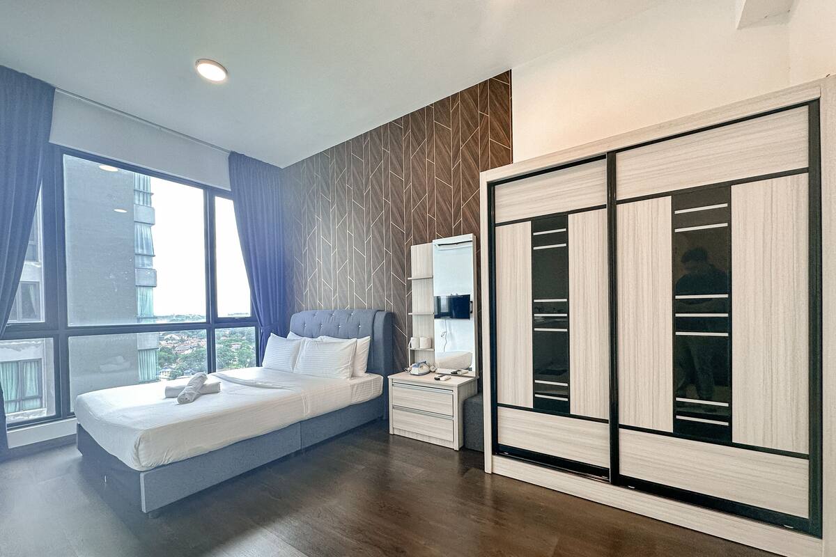 Une chambre moderne avec un grand lit, une armoire et une fenêtre avec des rideaux.