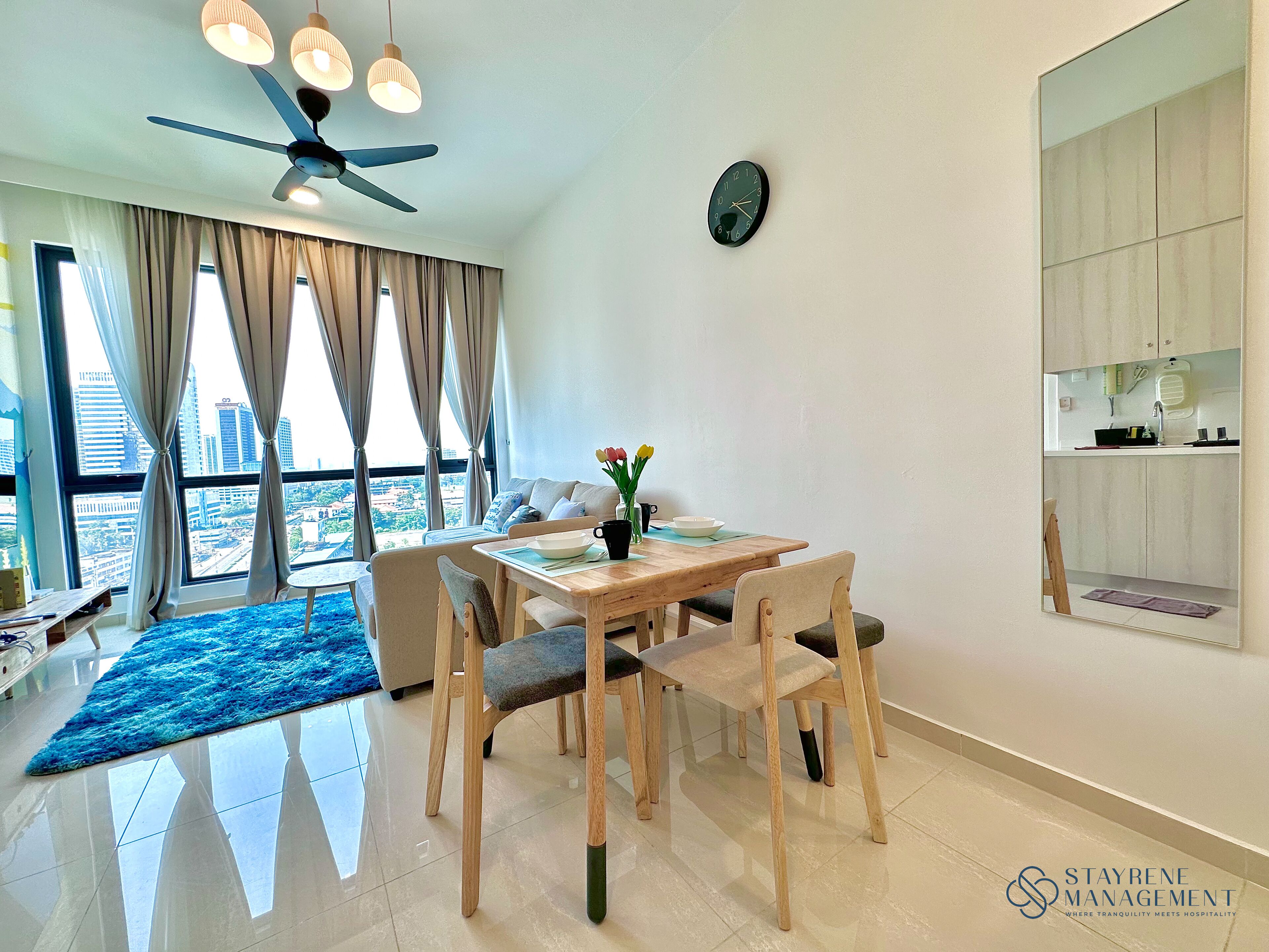 A modern dining area with a wooden table, chairs, and a vase of flowers.