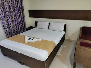Cozy retreat with a neatly made bed, nightstand, and lamp for a comfortable stay.