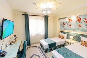 A hotel room with two beds, a desk with a computer, a telephone, and a television. - Gur Emir Palace (Samarkand)