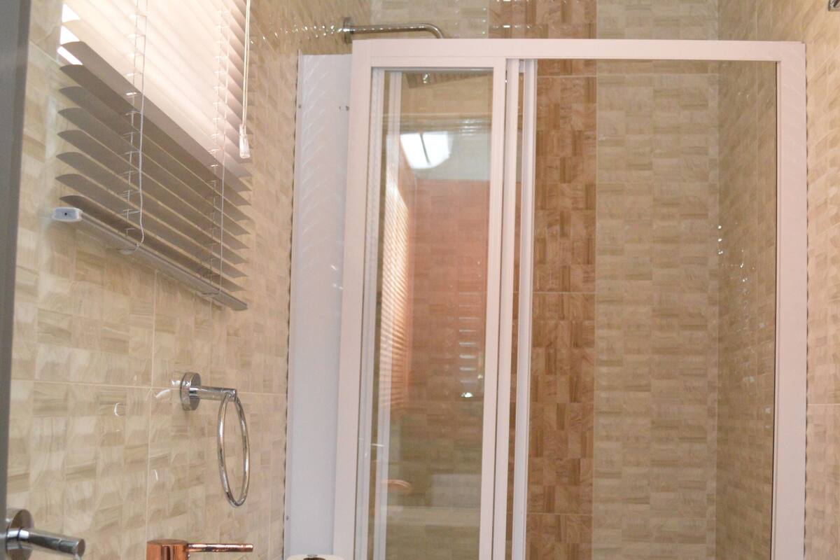 Un baño con lavamanos, inodoro y zona de ducha.