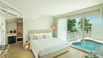 A modern hotel room with a large bed, a desk, and a view of a swimming pool.