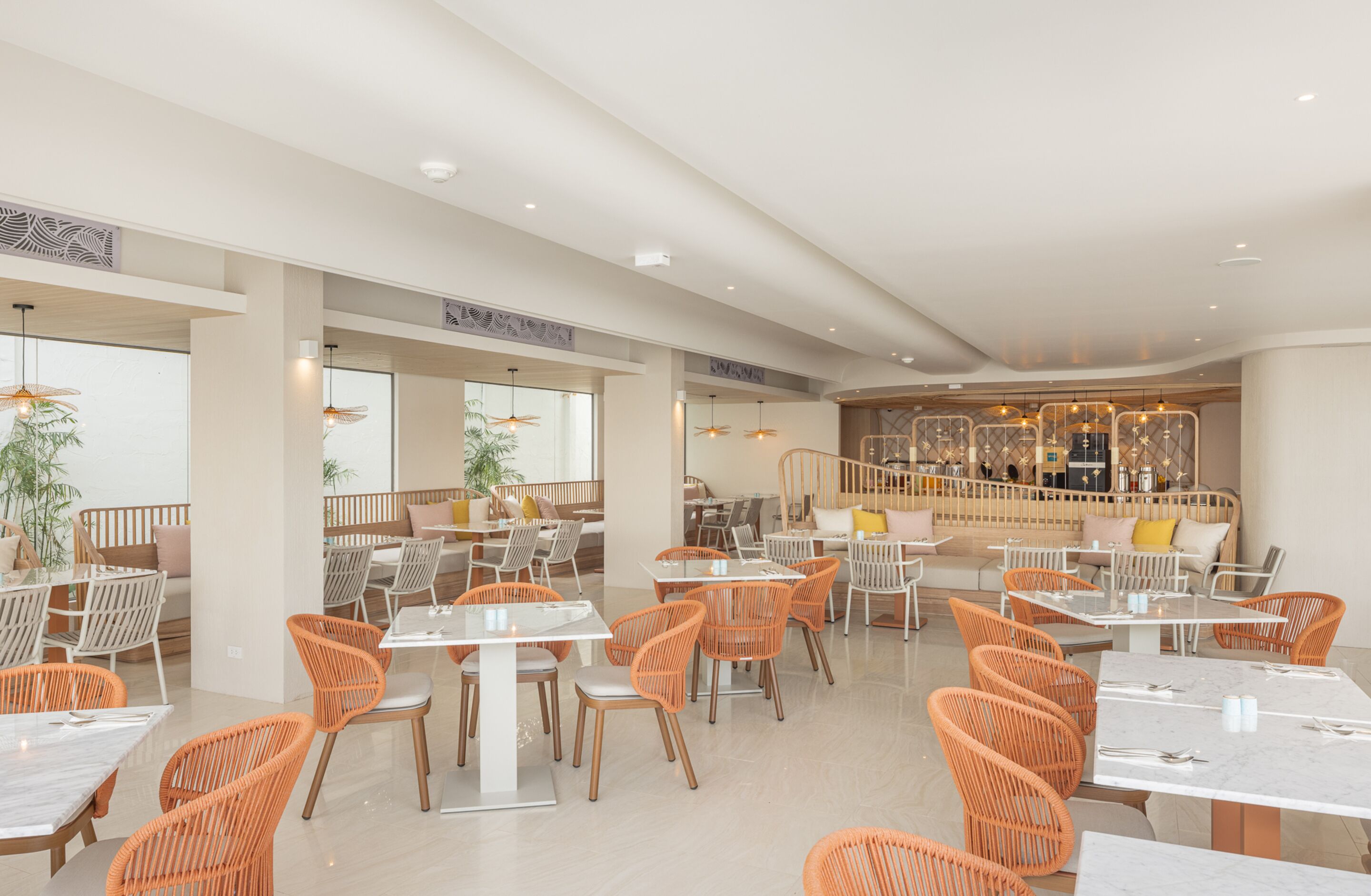 Un restaurant moderne doté d’une terrasse, d’un bar et agrémenté de plantes décoratives.
