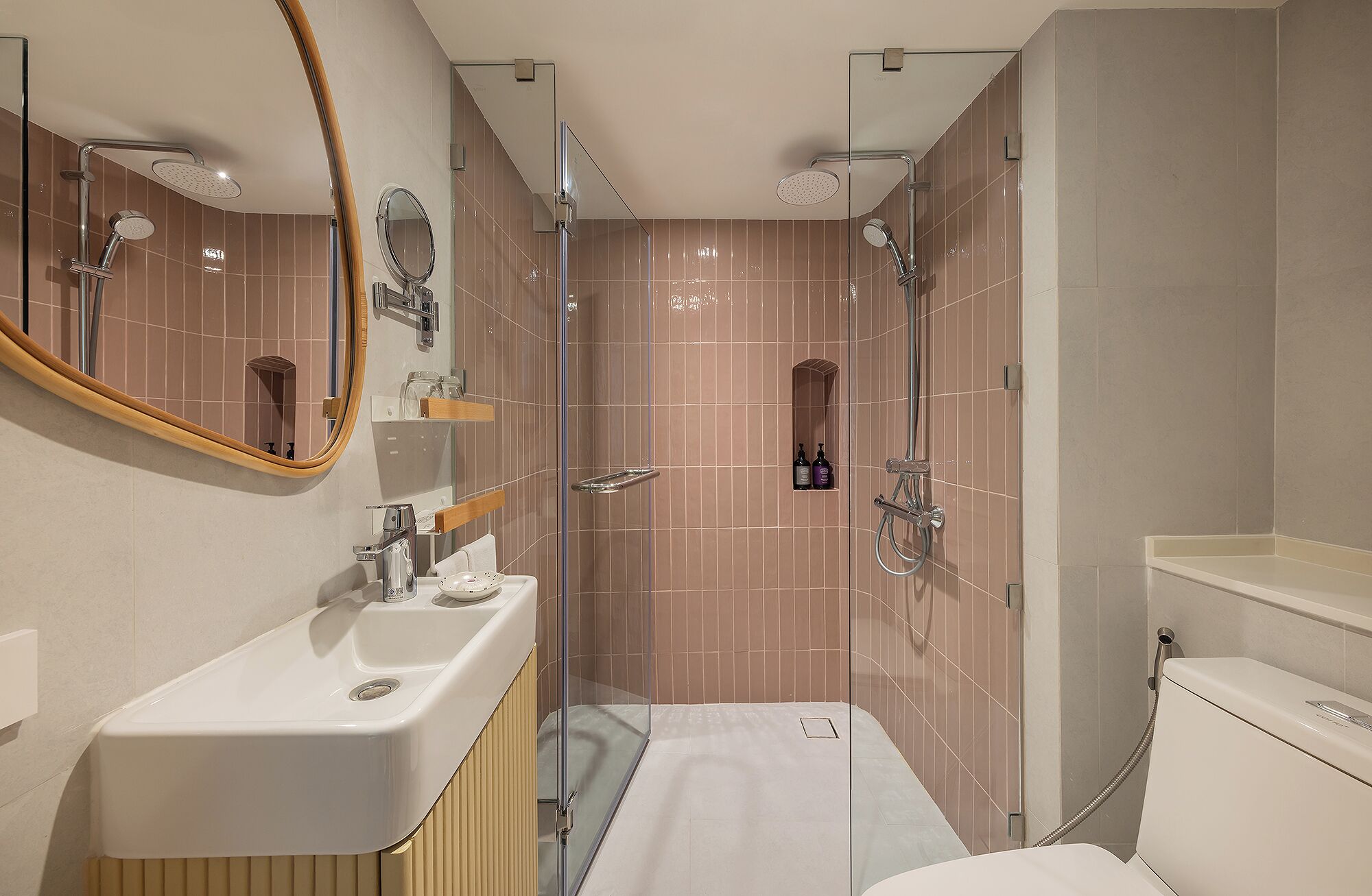 A modern bathroom with a glass shower enclosure, a vanity with a mirror, and a toilet.