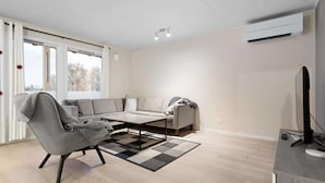 A modern living room with a sofa, armchair, and coffee table. - Lovly 3 Bedroom Apartment With the View of Aurora (Tromsø)