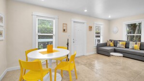 A living room with a gray sofa, yellow chairs, a white table, and a white door.