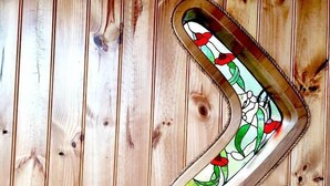 Een houten muur met een glas-in-loodraam met een bloemmotief.