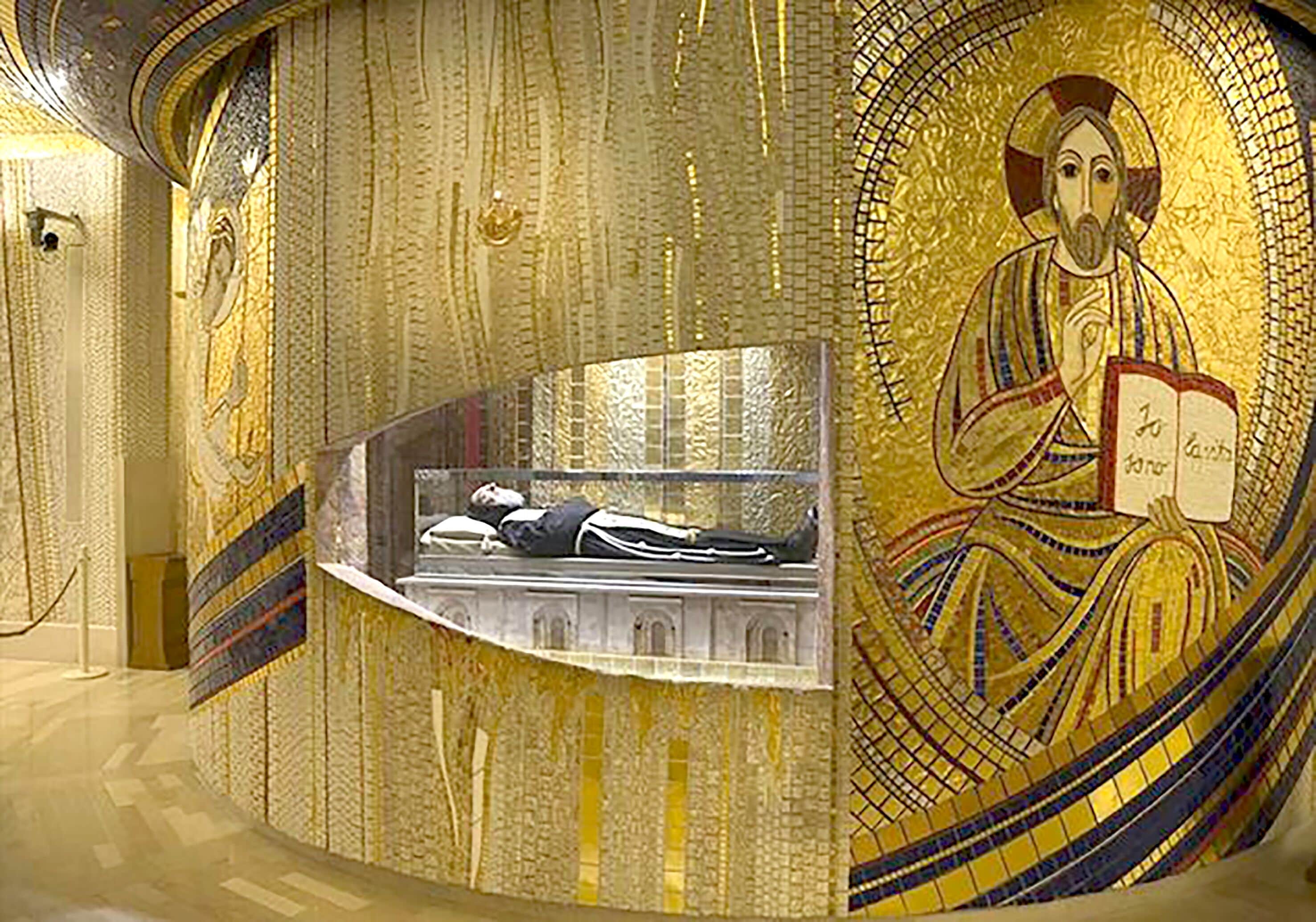 Ein Mosaik mit einer zentralen Figur, die ein Buch hält, umgeben von aufwendigen Mustern und einem Steinsarg.