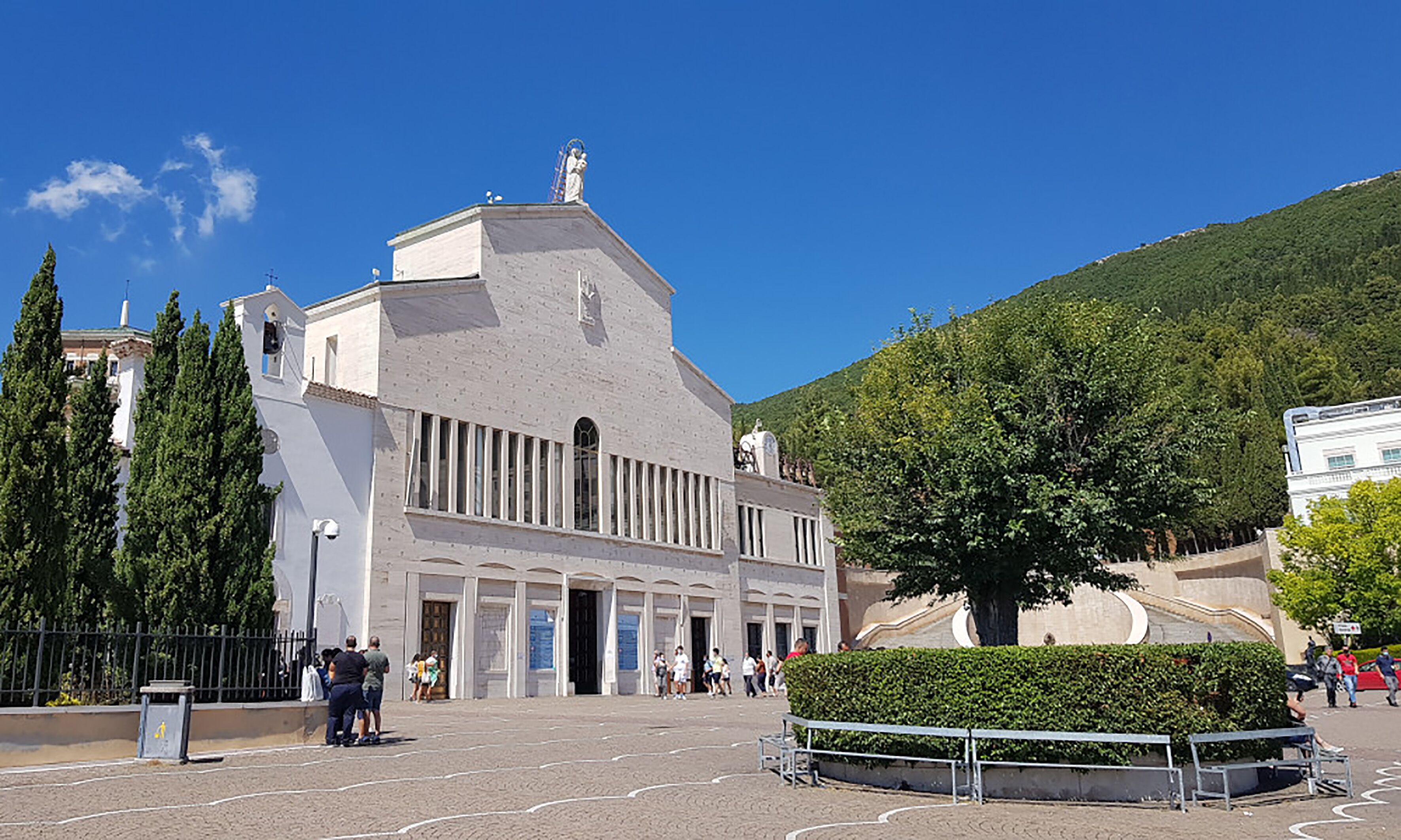 Un edificio grande con una entrada destacada y una estatua en la parte superior.