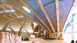 A spacious interior with a high ceiling, a central altar, and a seating area with a red barrier. - HOTEL HOUSE GARGANO (San Giovanni Rotondo)