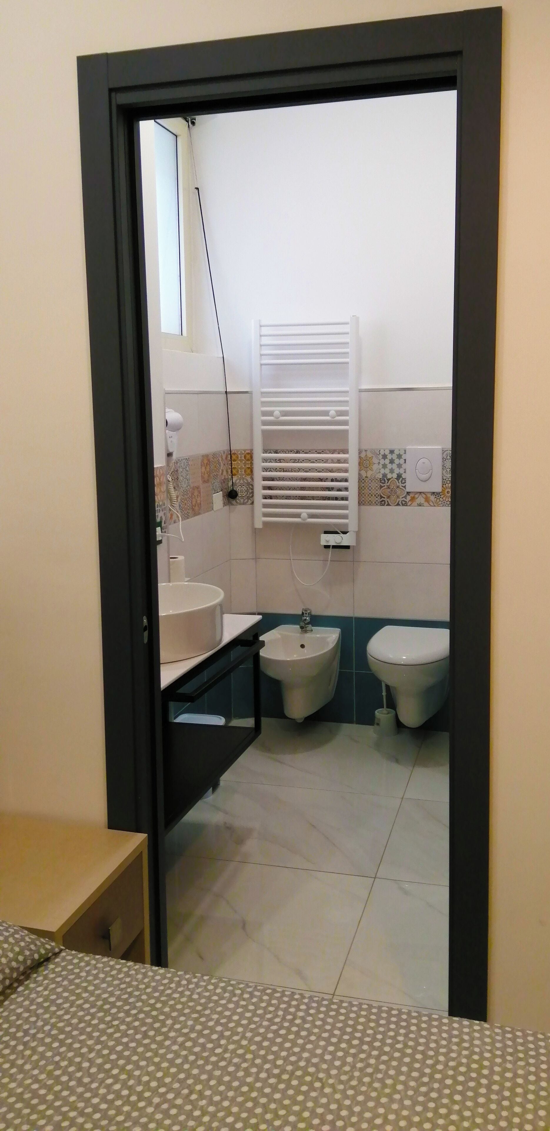 Une salle de bain équipée de toilettes, d’un bidet et d’un lavabo.