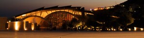 Un edificio grande e iluminado con una estructura de techo en arco singular.