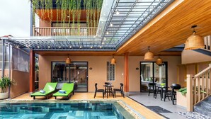 A modern hotel with a rooftop pool area, outdoor seating, and a glass ceiling. - The Linh Seaside Villa Hoi An (Da Nang)