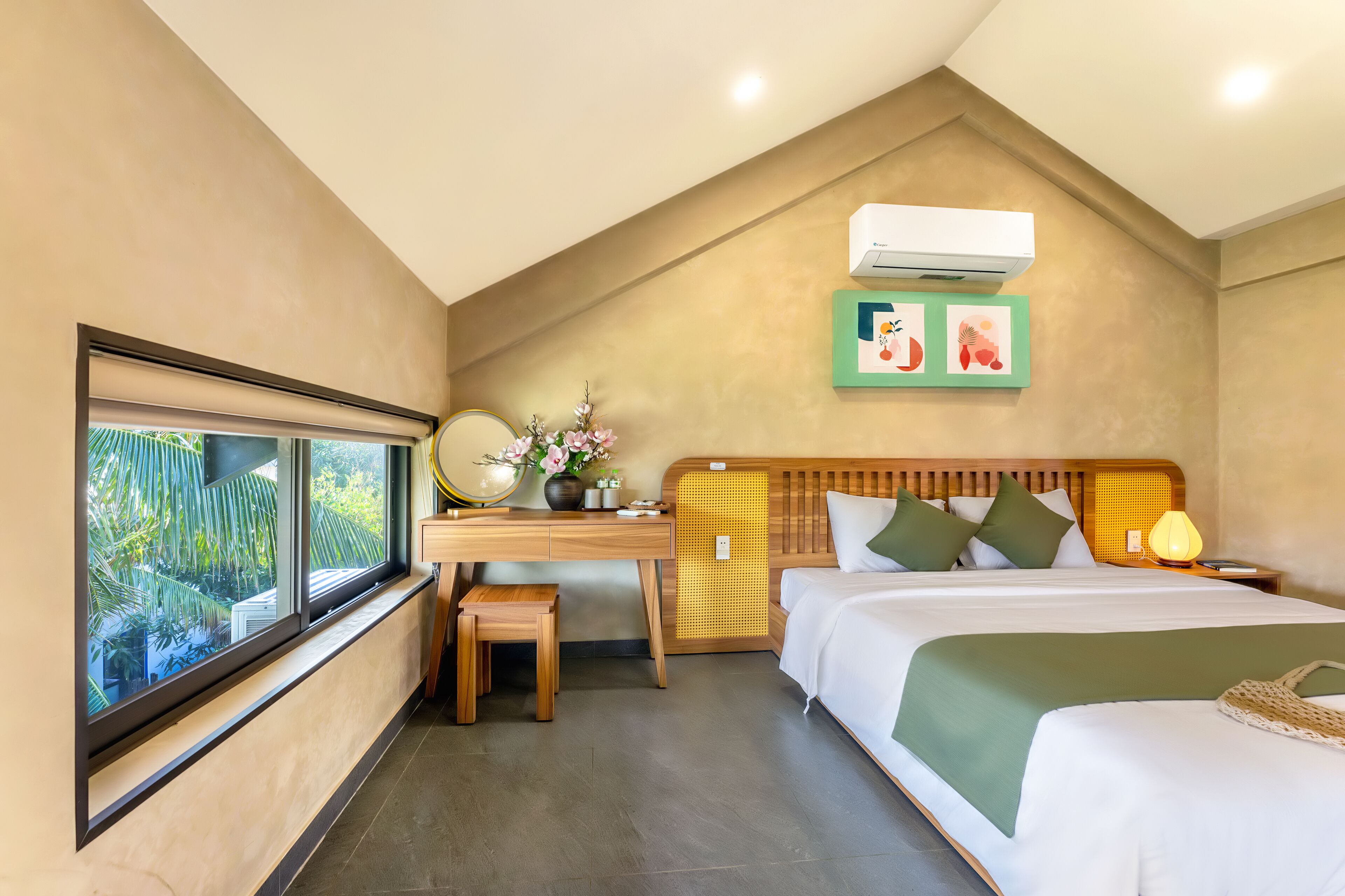 A hotel room with a bed, desk, and window.
